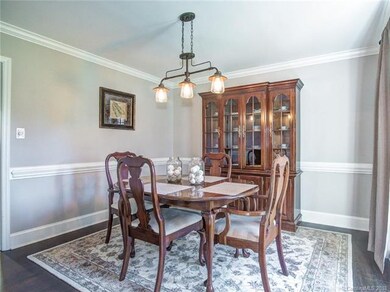 The dining room features laminate flooring, chair 