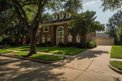 An arched entryway, and a detached garage, nestled