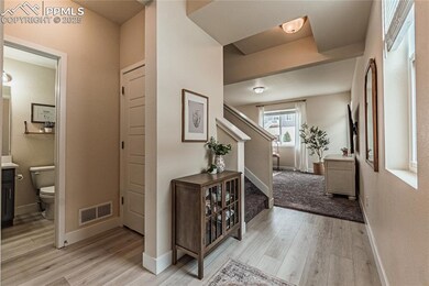 Foyer with stairway, light wood finished floors, and baseboards
