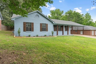 Ranch-style home with covered porch, brick siding, and a carport