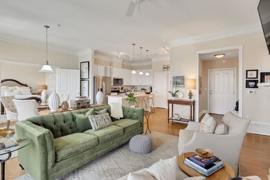 Living area with crown molding, light wood-type flooring, and a ceiling fan