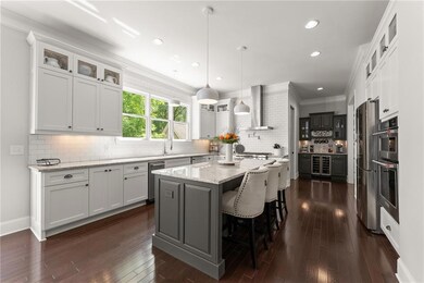 Kitchen featuring wall chimney range hood, a kitchen island, beverage cooler, backsplash, and dark wood-style flooring