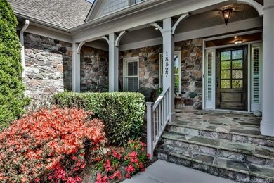 Handsome stone entry with rocking chair front porc