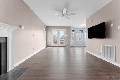 Unfurnished living room featuring ceiling fan, dar