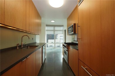 Kitchen featuring stainless steel appliances, sink, and dark tile floors