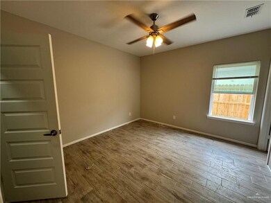 Spare room featuring ceiling fan, baseboards, and wood finished floors