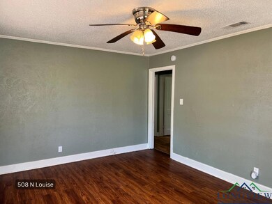 Spare room with dark wood-type flooring, ceiling fan, baseboards, ornamental molding, and a textured ceiling