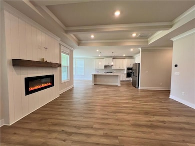 Unfurnished living room featuring crown molding, wood finished floors, a large fireplace, baseboards, and recessed lighting