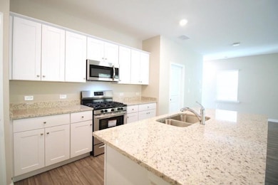 Kitchen with light wood-style floors, white cabine