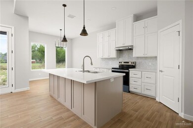Kitchen featuring stainless steel electric range oven, tasteful backsplash, a sink, under cabinet range hood, and light wood-style flooring