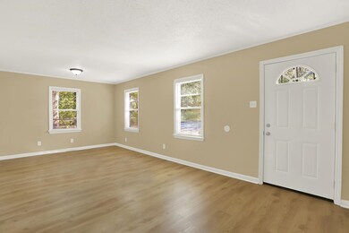 Entryway with a textured ceiling and light hardwoo