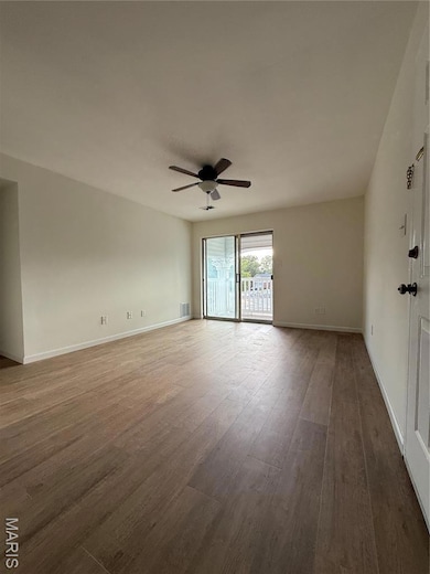Living room featuring wood-type flooring and a ceiling fan