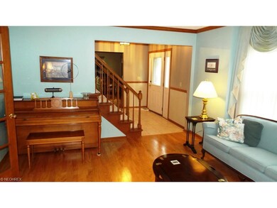 Formal living room with hardwood floor and crown moulding