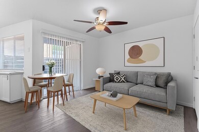 Living area with ceiling fan and wood finished fl