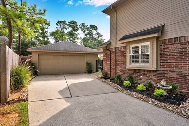 The landscaping extends on the side of the home and along the driveway by the garage. There is a wrought iron gate leading to the backyard and pool area.