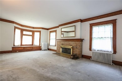 Living room with wood fireplace & built-in window 