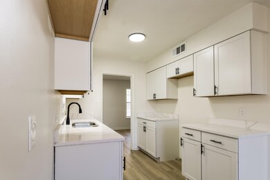 Kitchen with light stone countertops, sink, white 