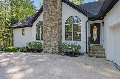 Entrance to property with driveway, a shingled roof, a chimney, and stucco siding