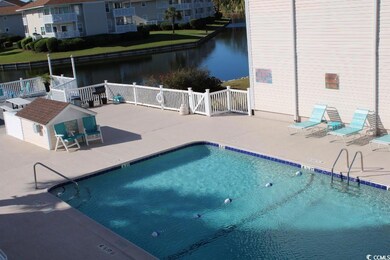Community pool featuring a water view and a patio area