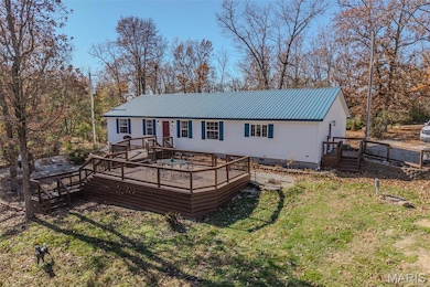 Back of house with a wooden deck, a metal roof, crawl space, and a lawn