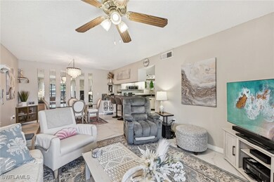 Living room with ceiling fan with notable chandeli