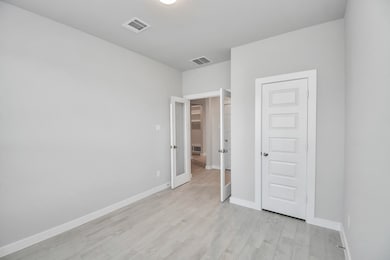 Experience the perfect blend of sophistication and warmth in this home office, boasting elegant wood-look tile flooring and flooded with natural light from expansive windows and French doors. Sample photo of completed home with similar floor plan. Actual colors and selections may vary.
