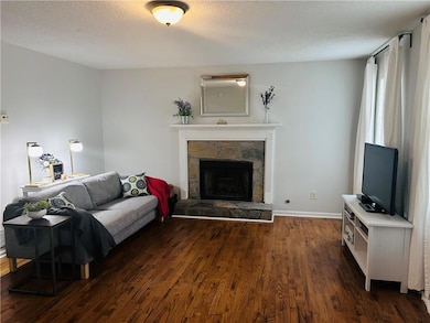 Living area with baseboards, a textured ceiling, a