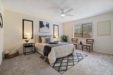 Carpeted bedroom with ceiling fan and baseboards