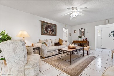 Living room featuring ceiling fan, a textured ceil
