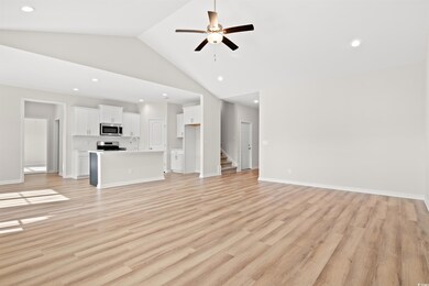 Unfurnished living room with ceiling fan, light ha