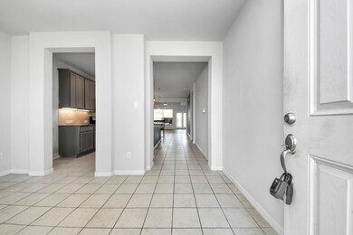 Bright entryway with tiled flooring leading to an