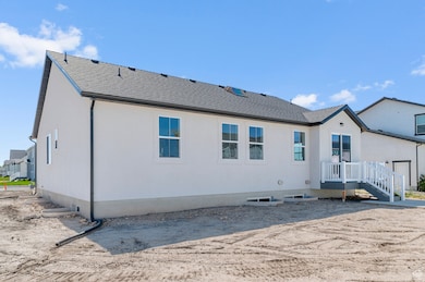 Back of property featuring a shingled roof