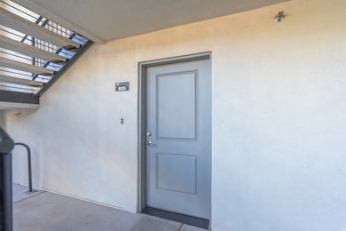 Entrance to property featuring stucco siding and a pergola