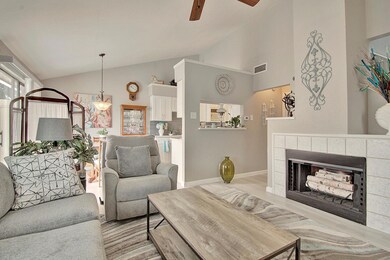Living room with a tile fireplace, ceiling fan, li