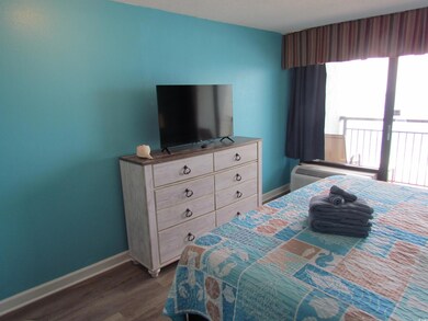 Bedroom with baseboards and dark wood-style flooring