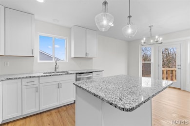 Kitchen featuring white cabinetry, light stone countertops, light wood-type flooring, and recessed lighting
