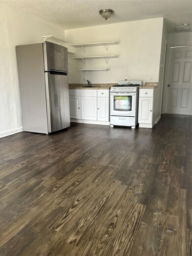 Bar with a sink, refrigerator, dark wood-style fl