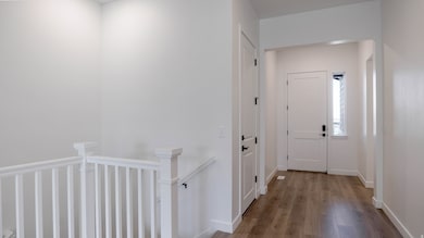 Hallway with an upstairs landing and wood finished floors