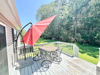 Deck with outdoor dining space and a lawn