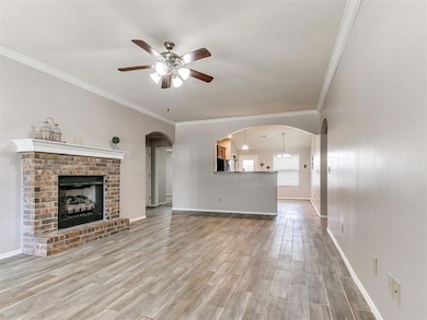 Unfurnished living room with baseboards, arched wa