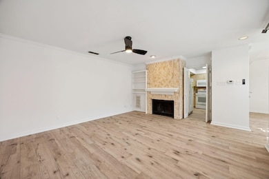 Unfurnished living room featuring a large fireplace, recessed lighting, light wood-type flooring, ceiling fan, and ornamental molding