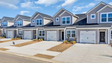 View of front of home with a garage, driveway, a s