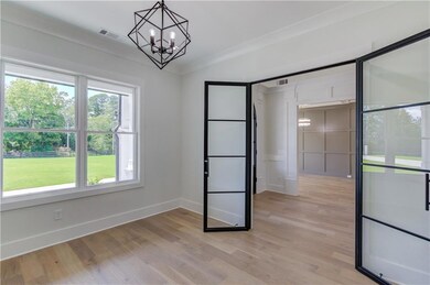Spare room with light hardwood / wood-style flooring, an inviting chandelier, and ornamental molding