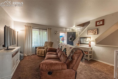Carpeted living room featuring a textured ceiling
