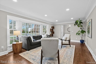 Living room featuring dark wood-style flooring, recessed lighting, ornamental molding, and arched walkways