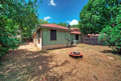 Back of property with cooling unit and a fire pit