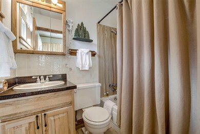 Full bathroom featuring decorative backsplash, toilet, tile walls, vanity, and shower / bathtub combination with curtain