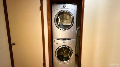 Washroom with stacked washing maching and dryer and laundry area