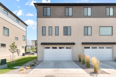 View of front of home featuring stucco siding, concrete driveway, and an attached garage