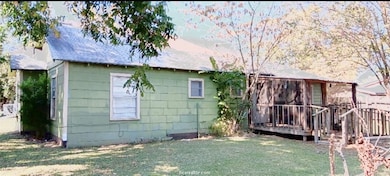 Back of house with a wooden deck, a shingled roof,